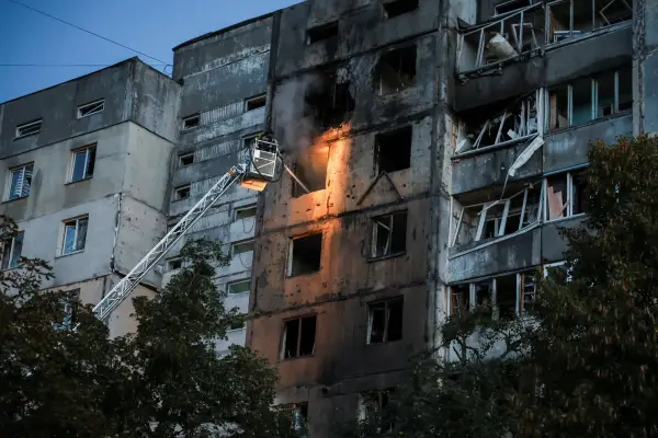 Пожежники працюють на місці ударів російських дронів по житловому будинку в Києві